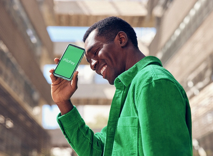 Homem segurando o celular com app PicPay