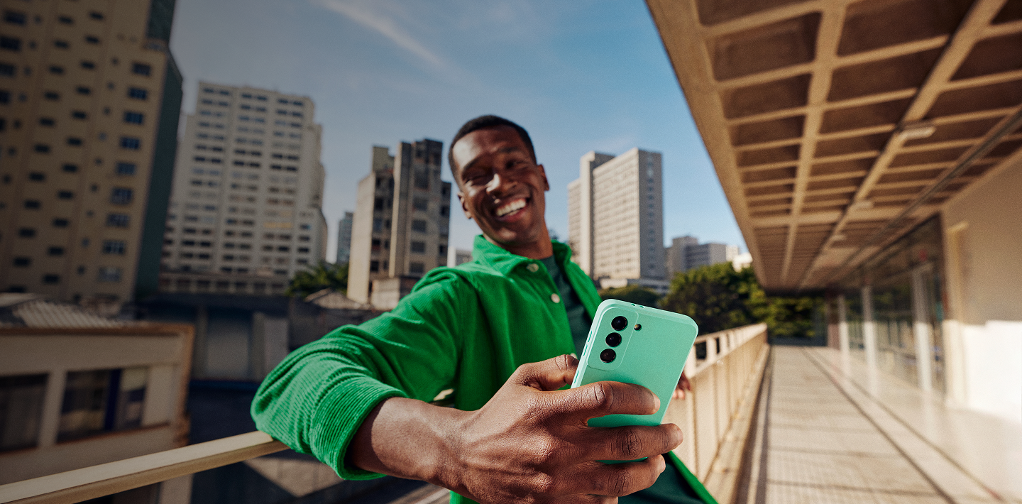 Homem sorrindo segurando o celular