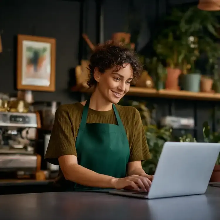 Mulher usando notebook em uma cafeteria.